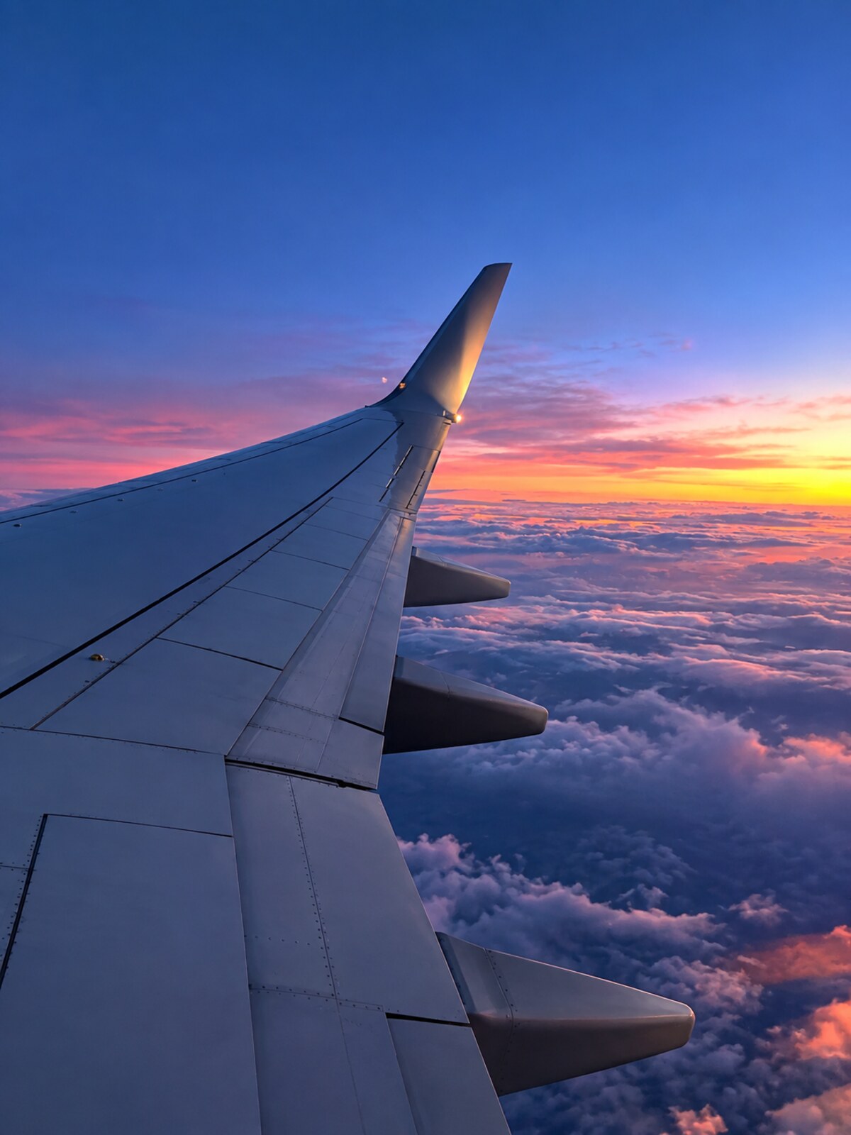 A wing over the clouds at sunset